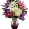 White asiatic lilies, white hydrangea, lavender stock, and purple alstroemeria are accented