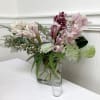 Pink and burgundy orchids arranged in a clear glass vase