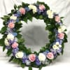 Circular floral wreath with pink and white roses and purple flowers