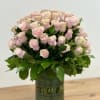 Pink roses arranged in a green glass vase