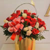Arrangement of red and white roses in a tall gold vase with a ribbon bow and butterfly accent