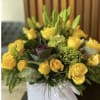 Yellow roses and lilies arranged in a white box
