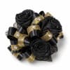 Three large black roses arranged as a bold wrist corsage make a
