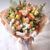 Bouquet of peach, yellow, and white roses wrapped in pastel paper