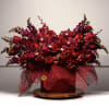 Large red floral arrangement in a round box with mesh wrap