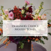 Mixed floral arrangement in a dark vase with pink, burgundy, and cream blooms