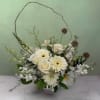 A full, abundant mix of elegant white and green blooms designed to