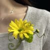 Yellow daisy boutonniere pinned to a sweater