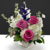 Pink roses and white flowers arranged in a clear square vase