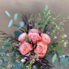 Pink roses arranged with eucalyptus and purple filler flowers