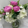 Pink peonies and white hydrangeas in a clear glass vase