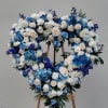 Heart-shaped floral wreath of white and blue roses on an easel
