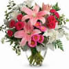 Pink lilies and red roses in a clear glass vase
