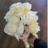 Handheld bouquet of white roses with a pale blush rose