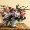 Different color of Daisy, and more wild flowers in white ceramic vase.