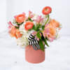 Marseille is a modern floral arrangement featuring layered peach roses, ranunculus, and