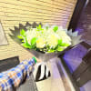 Beautiful bouquet of white roses in black wrapping paper or paper of