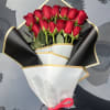Bouquet of red roses wrapped in black and white paper with a pink ribbon