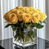 Yellow roses arranged in a clear square glass vase