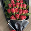 Bouquet of red roses wrapped in black paper with a red ribbon