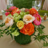 Garden roses, french peonies, hydrangea, Jasmine greens. Vase is wrapped in moss.