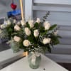 Rounded cluster of 12 creamy white roses with baby's breath and dark