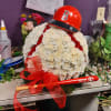 White floral arrangement with a red baseball helmet and bat