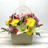 Basket arrangement with yellow daisies, pink carnations, and pale lilies
