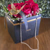 Red roses in a Dior gift box with a butterfly ribbon and chain handle