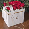 Red roses in a white gift box with a ribbon and chain strap