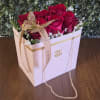 Red roses in a white gift box with a ribbon and butterfly decoration