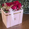 Pink roses in a decorative gift box with a ribbon and butterfly ornament