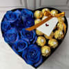 Heart-shaped box with blue roses and gold-wrapped chocolates