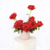 Red roses arranged in a pink vase