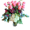 Soft pink roses rise above a cloud of cream hydrangea in this