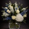 Creamy white roses and lush white hydrangeas meet vivid blue florals in