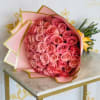 A lush cluster of pink roses arranged in a rounded, hand-tied form-this