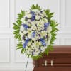 Pay your respects with a standing tribute of white and blue florals