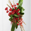 Red roses with anthuriums and tropical foliage on a stand