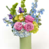 Soft roses and blue blooms with fresh greenery, arranged in a light