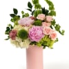 Delicate peonies and soft blooms in blush tones, arranged with fresh greenery