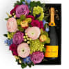A pastel floral arrangement in a wood box paired with Veuve Clicquot