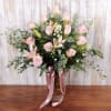 Pale pink roses and open pink lilies take center stage in this