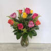 Glass vase of mixed pink, yellow, orange, and lavender roses with yellow filler flowers