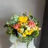 This beautiful flower arrangement of fresh mixed seasonal blooms is made by