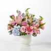 Soft pastel pink lilies and roses mingle with pale blue hydrangeas and
