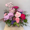 Pink and lavender mixed bouquet with a Mother's Day topper in a square vase
