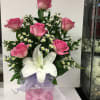 Soft pink roses clustered around a single dramatic white lily make this