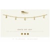 Gold charm necklace with small discs and crystal accents on a branded display card