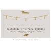Gold chain necklace with small feather and crystal charms displayed on a white card with printed text.